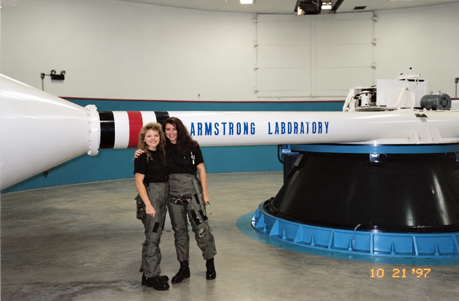 Dr. Kelly Harvey with a fellow trainee beside the Armstrong Laboratory centrifuge
